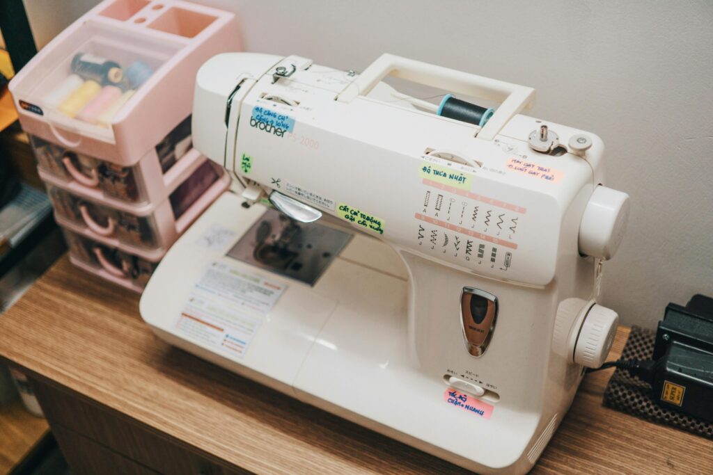 Close-up of a sewing machine and threads in a workshop setting.